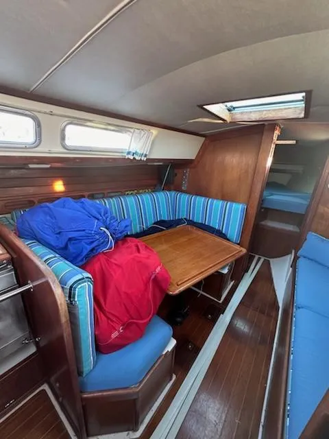 Slide: The Image of Interior of 1985 Ericson 30 Plus sailboat with striped seating and wooden table. - 17