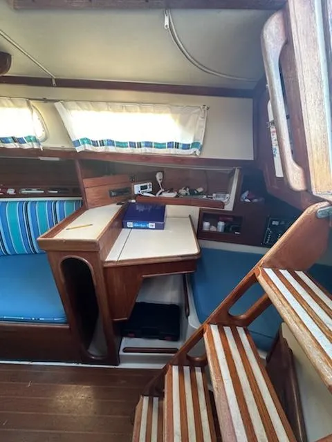 Slide: The Image of Interior of 1985 Ericson 30 Plus sailboat with wooden furnishings and blue-striped cushions. - 19