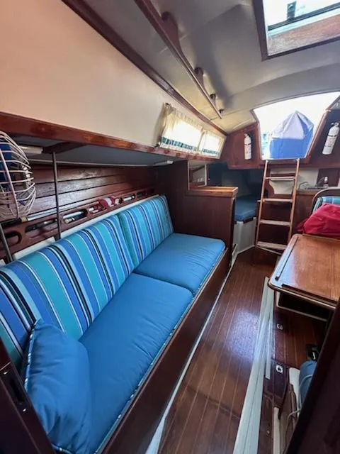 Slide: The Image of Interior of 1985 Ericson 30 Plus sailboat with blue-striped seating and wooden finishes. - 25