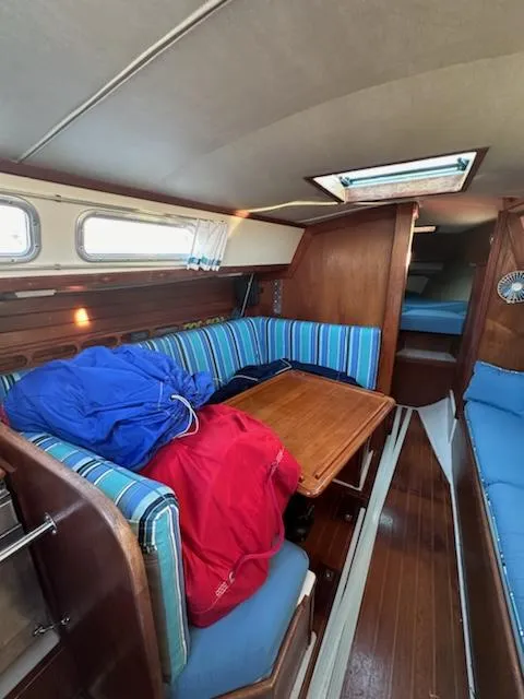 Slide: The Image of Interior of 1985 Ericson 30 Plus sailboat with striped seating and wooden table. - 26