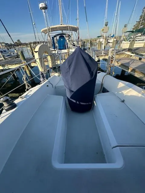 Slide: The Image of 1985 Ericson 30 Plus sailboat docked at marina, featuring covered equipment on deck. - 3