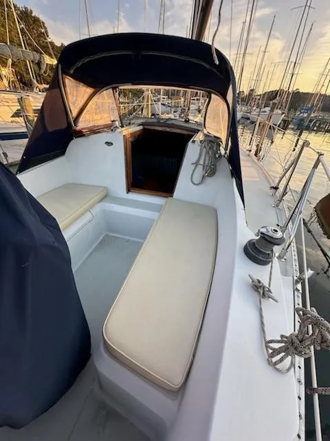 Slide: The Image of 1985 Ericson 30 Plus sailboat cockpit with seating, docked at sunset. - 32