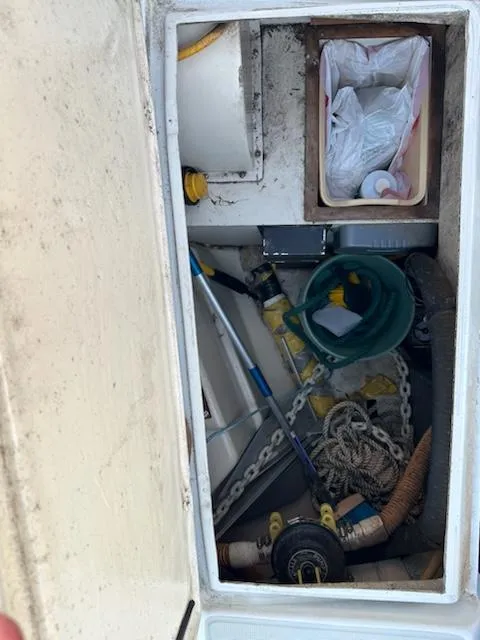 Slide: The Image of Storage compartment on a 1985 Ericson 30 Plus sailboat with ropes, chains, and cleaning supplies. - 35