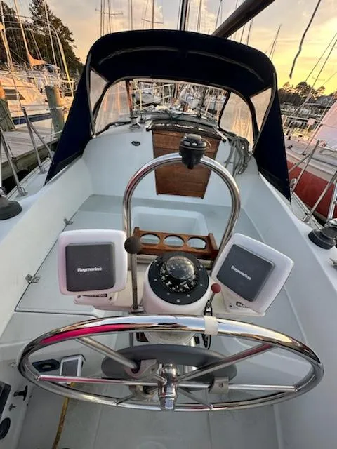 Slide: The Image of 1985 Ericson 30 Plus sailboat cockpit with steering wheel, navigation instruments, and compass. - 36