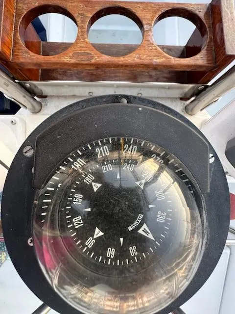 Slide: The Image of Compass on 1985 Ericson 30 Plus sailboat, featuring a wooden holder with circular cutouts. - 39