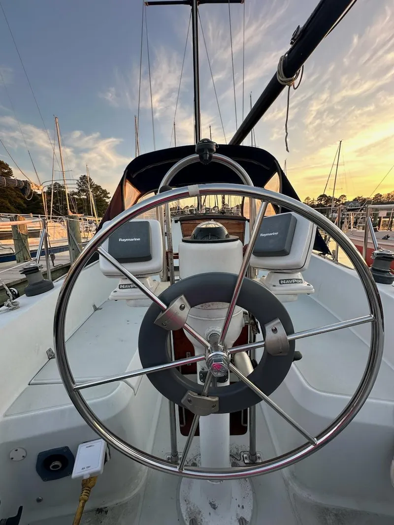 Slide: The Image of 1985 Ericson 30 Plus sailboat cockpit with steering wheel at sunset in marina. - 41