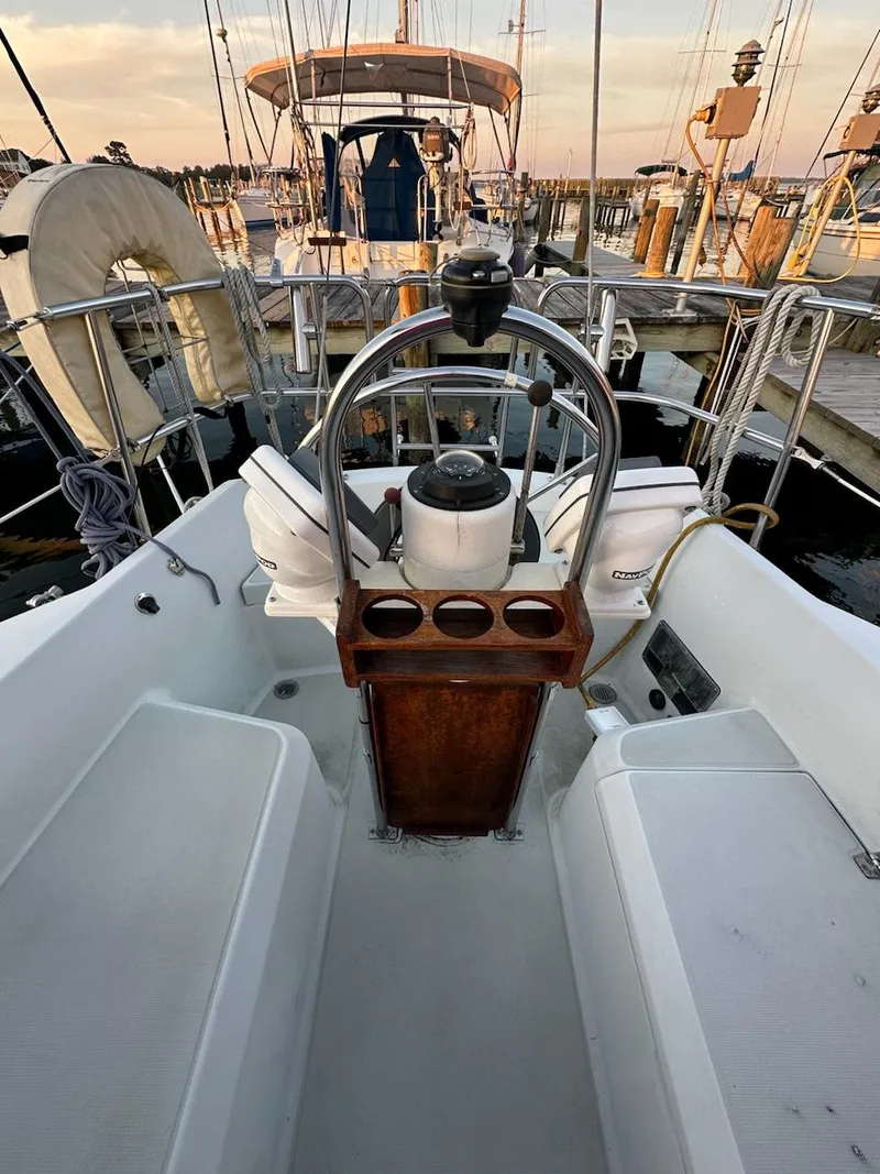 Slide: The Image of 1985 Ericson 30 Plus sailboat cockpit with steering wheel and marina background. - 42