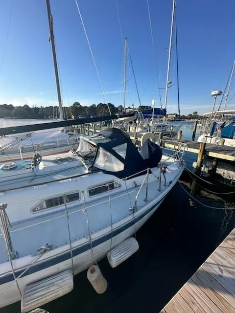 Slide: The Image of 1985 Ericson 30 Plus sailboat docked at a marina under clear blue skies. - 43
