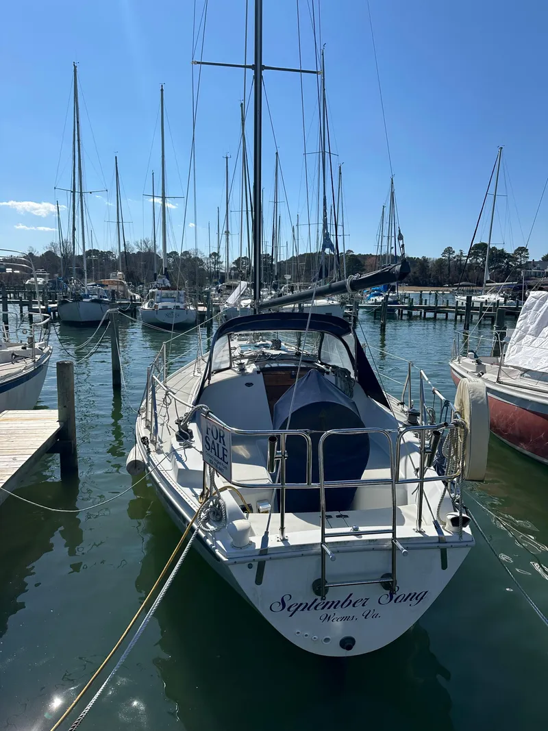 Slide: The Image of 1985 Ericson 30 Plus sailboat docked in a marina, named "September Song." - 48