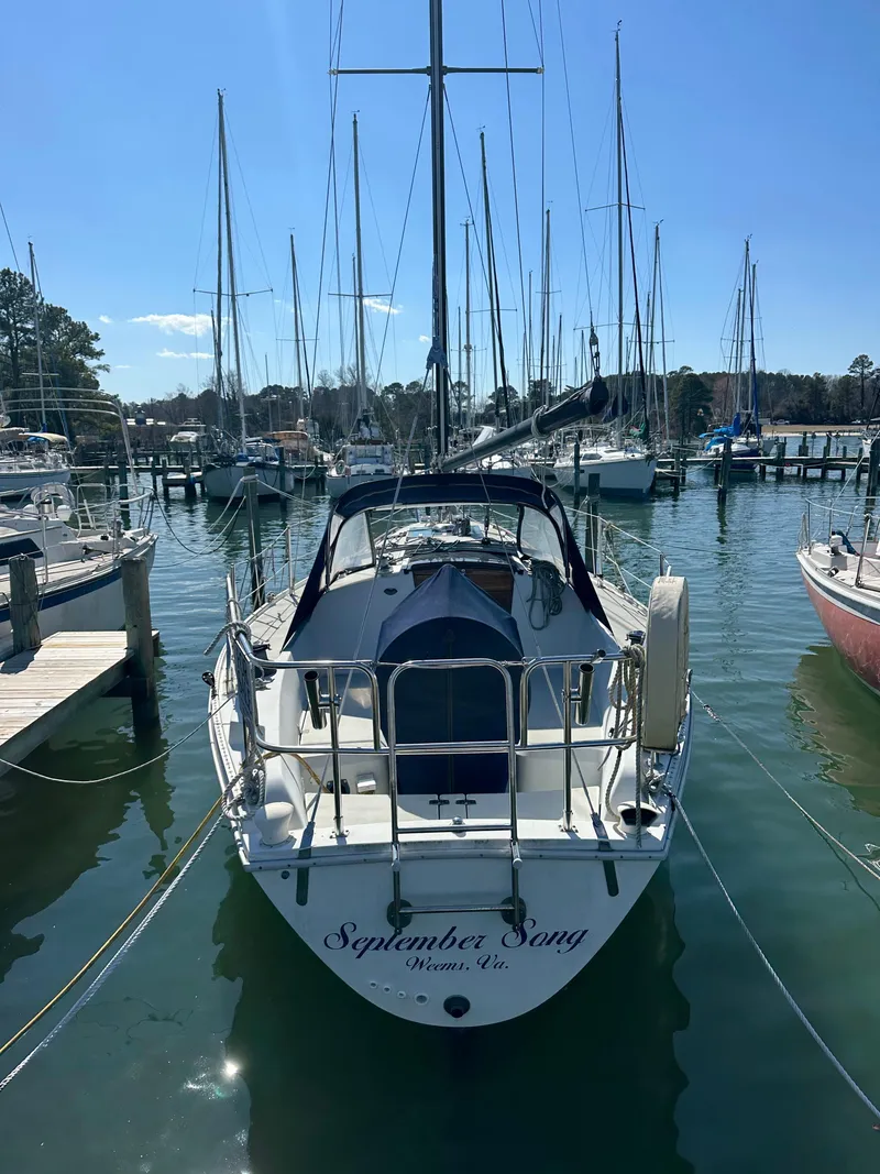 Slide: The Image of 1985 Ericson 30 Plus sailboat docked in a marina, surrounded by other boats. - 49