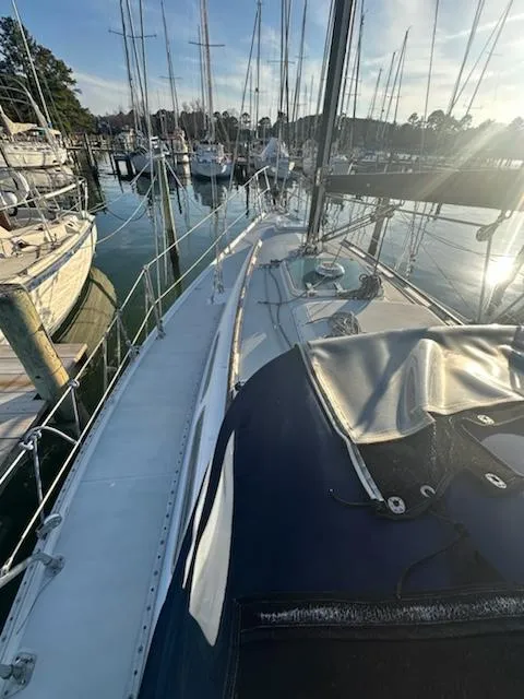 Slide: The Image of 1985 Ericson 30 Plus sailboat docked in a marina, surrounded by other boats. - 5