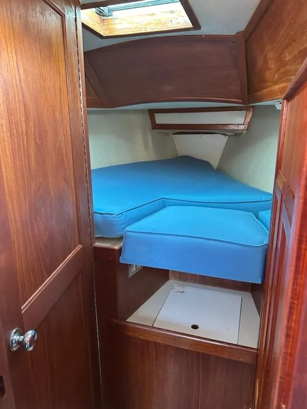 Slide: The Image of 1985 Ericson 30 Plus sailboat interior with blue cushions and wooden cabinetry. - 6