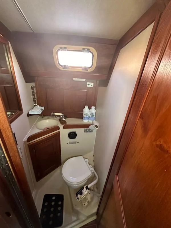 Slide: The Image of Compact bathroom in 1985 Ericson 30 Plus sailboat with wooden cabinetry and porthole window. - 8