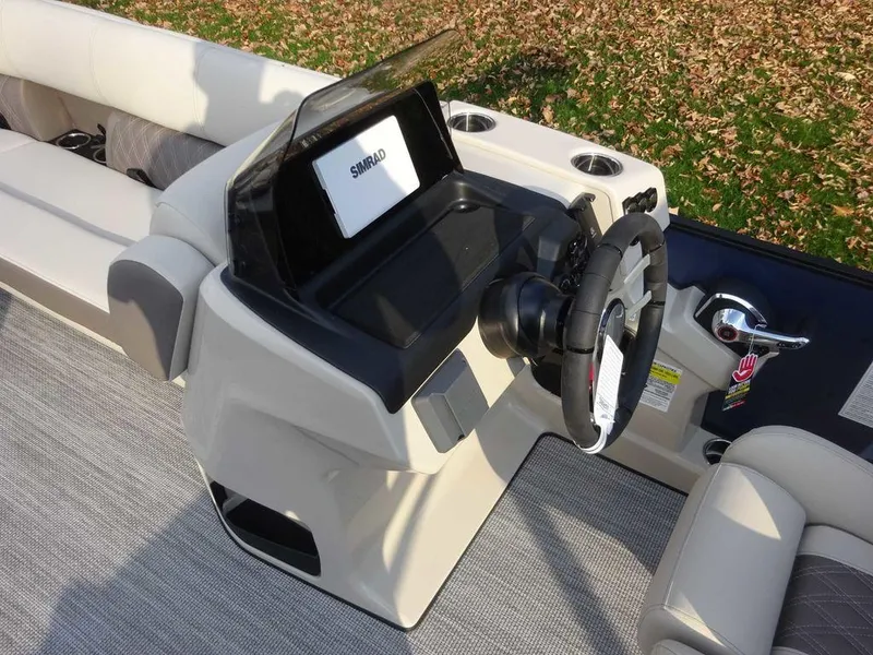 Slide: The Image of 2024 Harris Sunliner 230 boat dashboard with steering wheel and Simrad display. - 12
