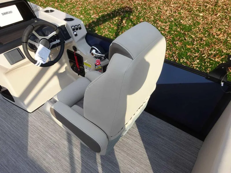 Slide: The Image of 2024 Harris Sunliner 230 boat interior with steering wheel and captain's chair. - 15