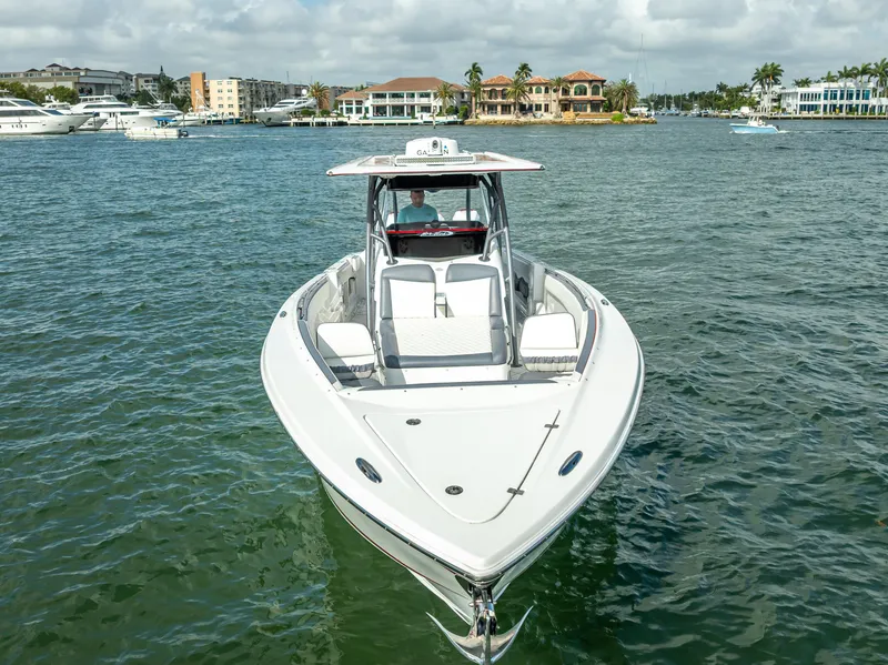 Slide: The Image of 2018 Nor-Tech 390 boat on water, front view, with coastal buildings in background. - 1