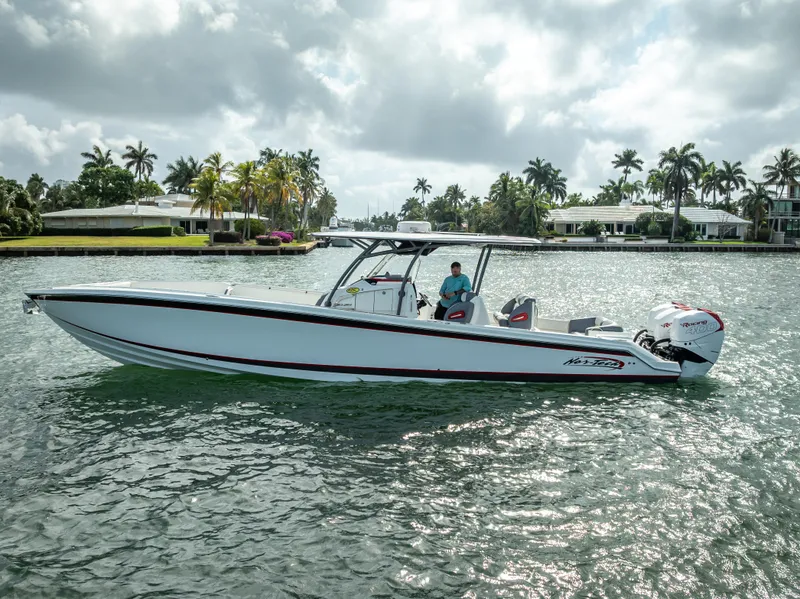 Slide: The Image of 2018 Nor-Tech 390 boat cruising on a sunny day in a scenic waterfront area. - 10
