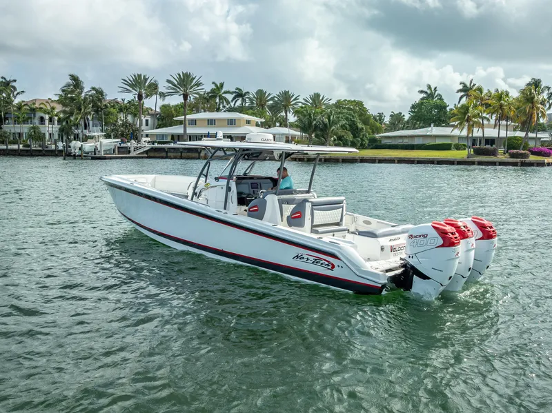 Slide: The Image of 2018 Nor-Tech 390 boat cruising on a scenic waterway with palm trees in the background. - 11