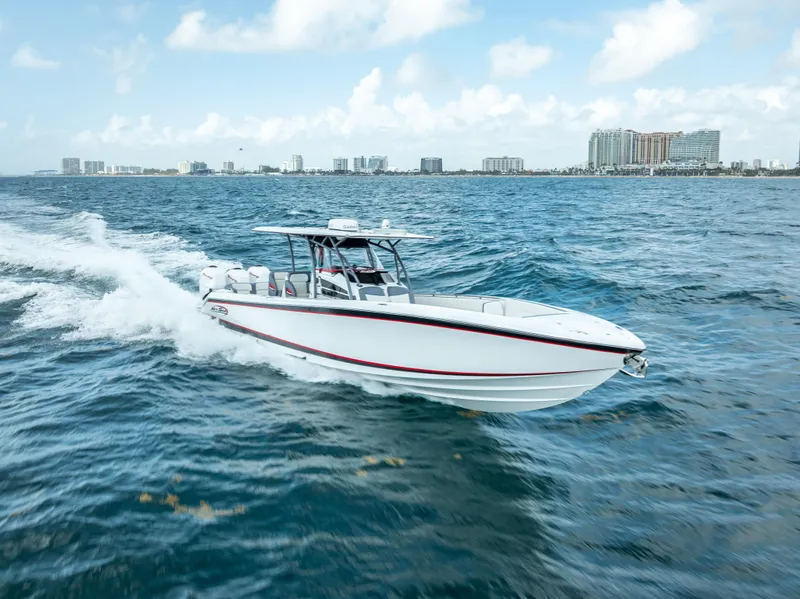 Slide: The Image of 2018 Nor-Tech 390 boat cruising on open water with city skyline in background. - 12