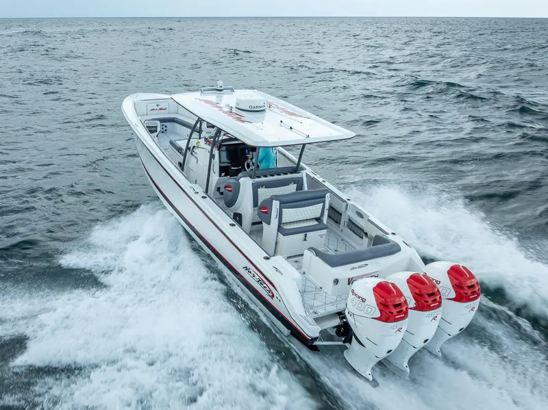 Slide: The Image of 2018 Nor-Tech 390 boat cruising on open water with triple outboard engines. - 17