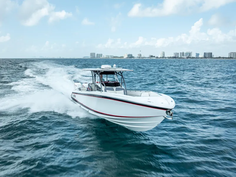 Slide: The Image of 2018 Nor-Tech 390 boat cruising on open water with city skyline in background. - 18