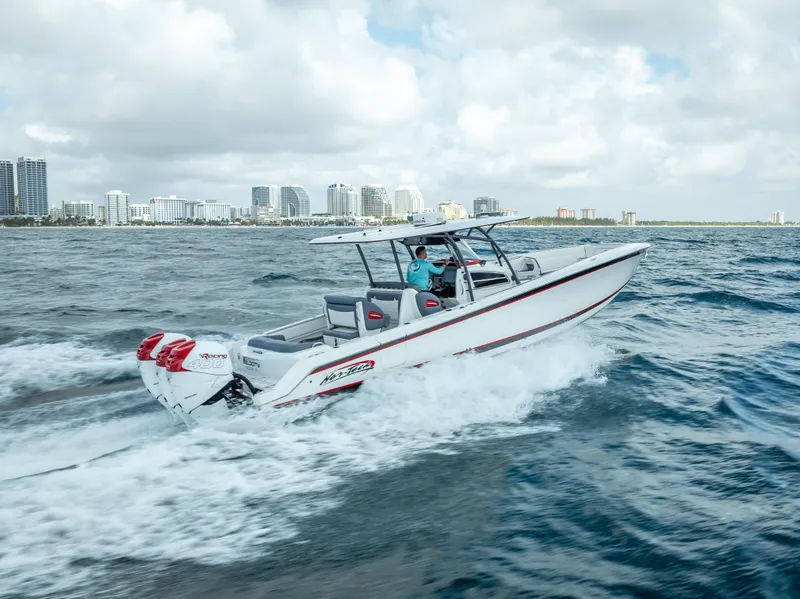 Slide: The Image of 2018 Nor-Tech 390 boat cruising on open water with city skyline in background. - 19