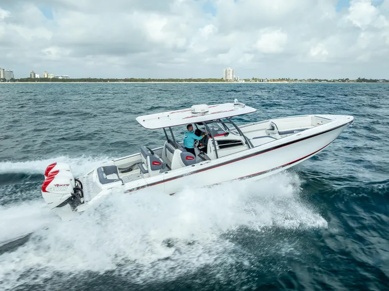 Slide: The Image of 2018 Nor-Tech 390 boat cruising on open water under a cloudy sky. - 21