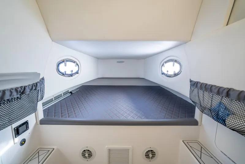 Slide: The Image of 2018 Nor-Tech 390 cabin interior with bed, portholes, and storage nets. - 24