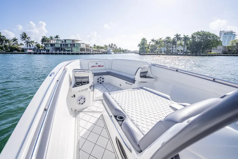 Slide: The Image of 2018 Nor-Tech 390 boat with luxurious seating, cruising on a sunny waterfront. - 27