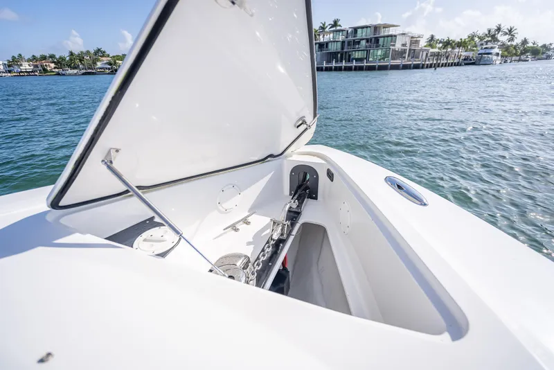 Slide: The Image of 2018 Nor-Tech 390 boat with open storage compartment, docked near waterfront homes. - 28