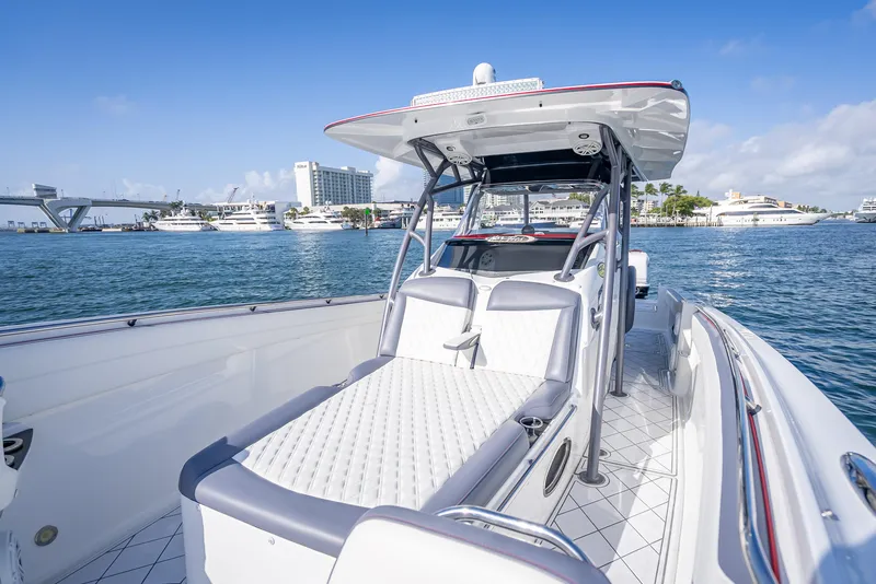 Slide: The Image of 2018 Nor-Tech 390 boat with luxurious seating, docked in a marina under clear blue skies. - 31