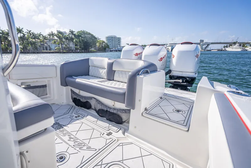Slide: The Image of 2018 Nor-Tech 390 boat interior with seating and multiple outboard engines on a sunny day. - 34