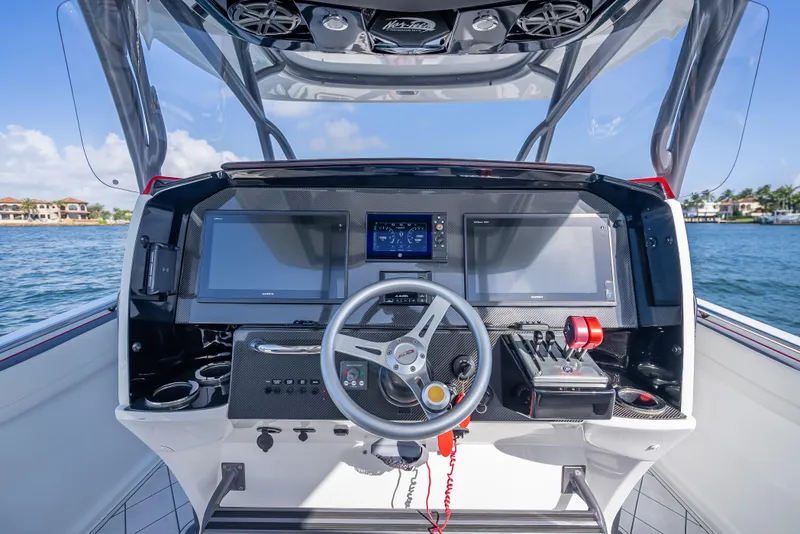 Slide: The Image of 2018 Nor-Tech 390 boat dashboard with modern controls and navigation screens on a sunny day. - 38