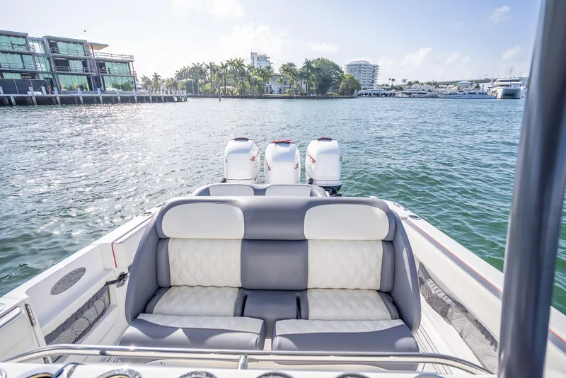 Slide: The Image of 2018 Nor-Tech 390 boat with triple engines, luxurious seating, and scenic waterfront view. - 39