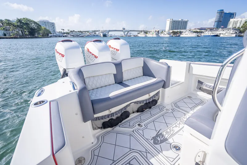 Slide: The Image of 2018 Nor-Tech 390 boat with triple engines, luxurious seating, and scenic waterfront view. - 41