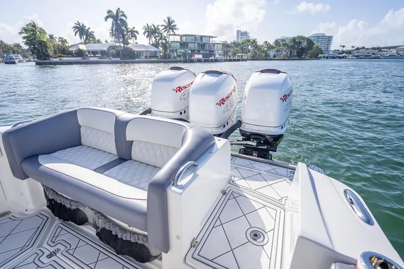 Slide: The Image of 2018 Nor-Tech 390 boat with triple engines, luxurious seating, and scenic waterfront view. - 44
