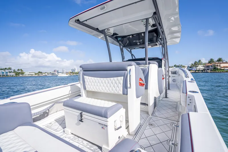 Slide: The Image of 2018 Nor-Tech 390 boat interior with luxurious seating and open deck, set against a scenic waterfront. - 47