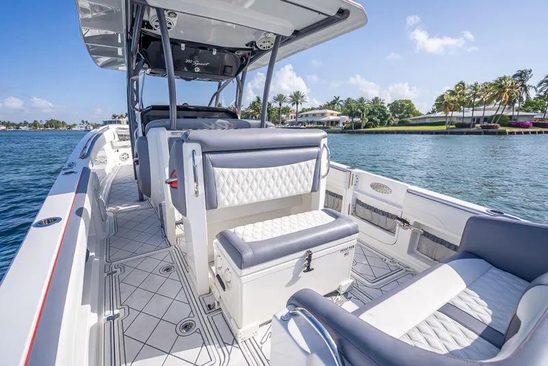Slide: The Image of 2018 Nor-Tech 390 boat interior with luxurious seating, on a sunny waterfront. - 49