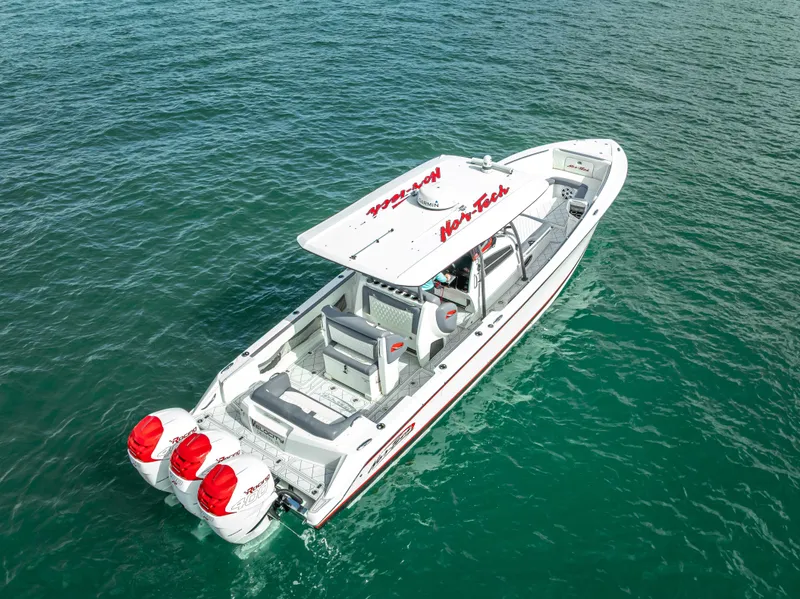 Slide: The Image of 2018 Nor-Tech 390 boat with triple outboard engines on clear blue water. - 5