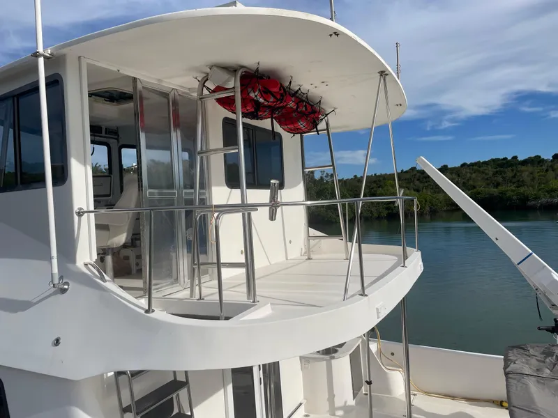 Slide: The Image of 2004 Endeavour Explorer 46 PowerCat docked by serene waters, showcasing upper deck and railing. - 20
