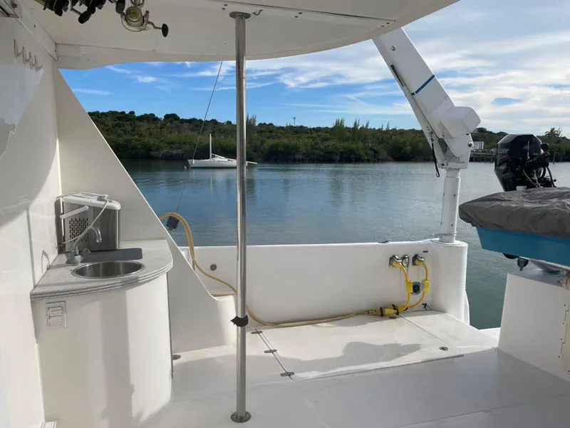 Slide: The Image of 2004 Endeavour Explorer 46 PowerCat deck with sink, overlooking serene water and distant sailboat. - 22