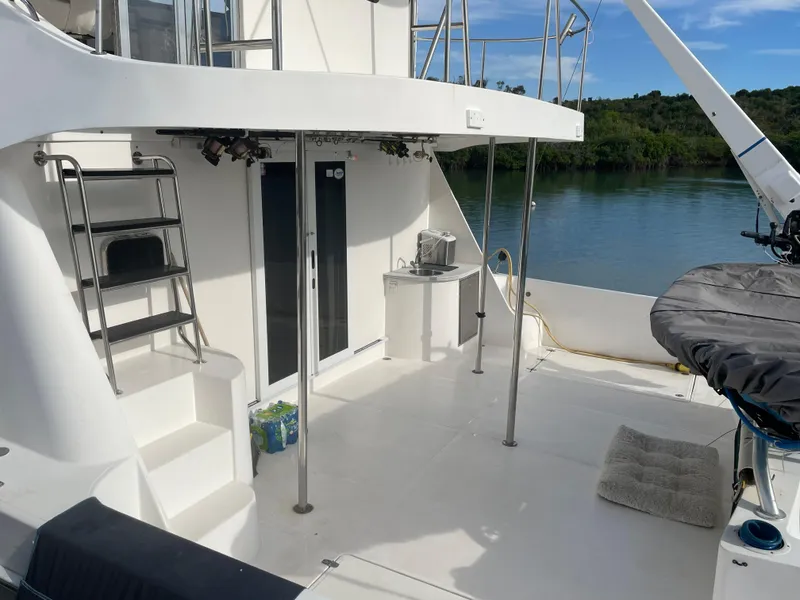 Slide: The Image of 2004 Endeavour Explorer 46 PowerCat deck with stairs, outdoor seating, and scenic water view. - 23