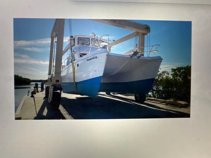 Slide: The Image of 2004 Endeavour Explorer 46 PowerCat on lift, dockside, under clear blue sky. - 3