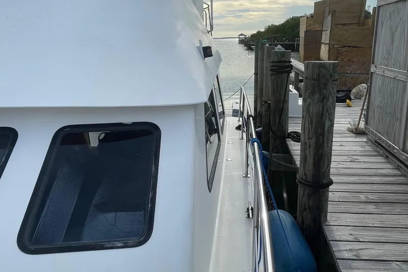 Slide: The Image of 2004 Endeavour Explorer 46 PowerCat docked by wooden pier, side view. - 37