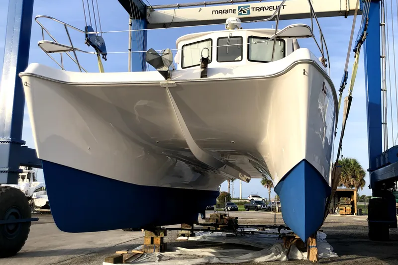 Slide: The Image of 2004 Endeavour Explorer 46 PowerCat on lift, showcasing sleek design and blue hull. - 4