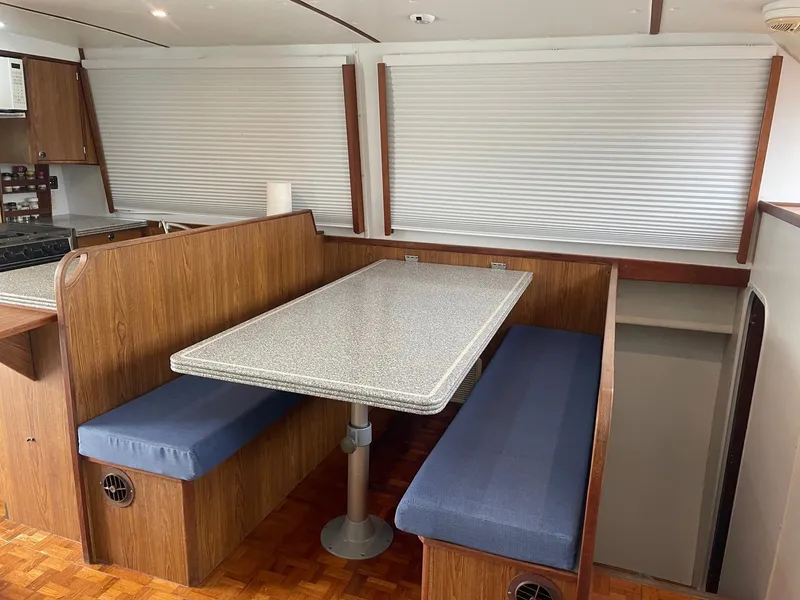 Slide: The Image of 2004 Endeavour Explorer 46 PowerCat interior with dining area, featuring wood finish and blue seating. - 41