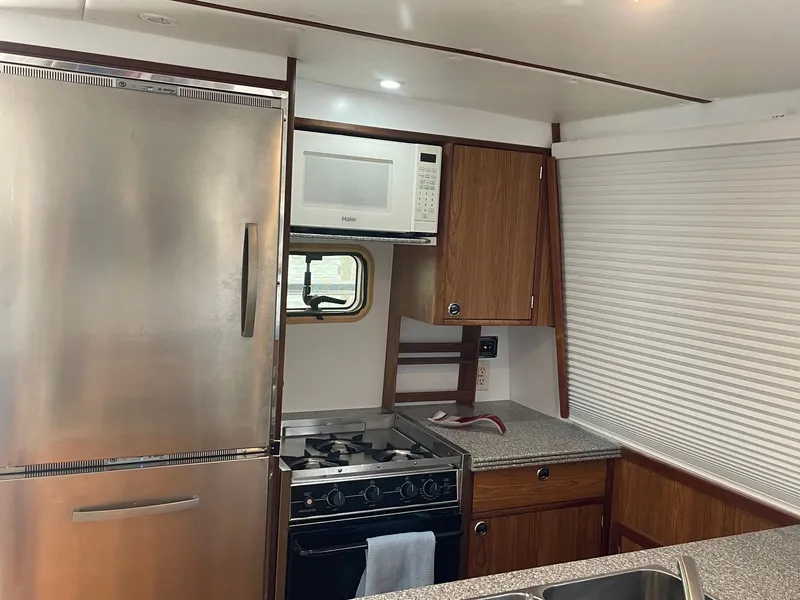 Slide: The Image of Kitchen area of 2004 Endeavour Explorer 46 PowerCat with appliances and wooden cabinetry. - 42