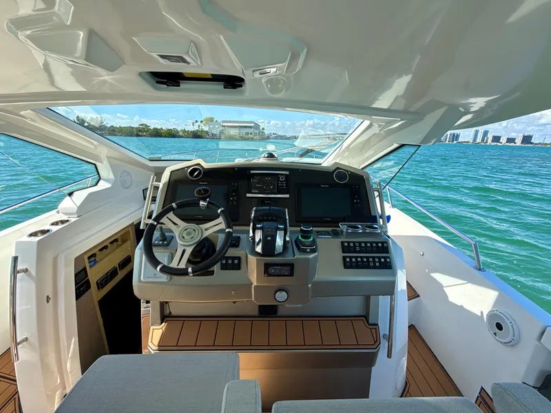 Slide: The Image of 2019 Azimut 40 Verve yacht cockpit with modern controls, overlooking serene blue waters. - 15