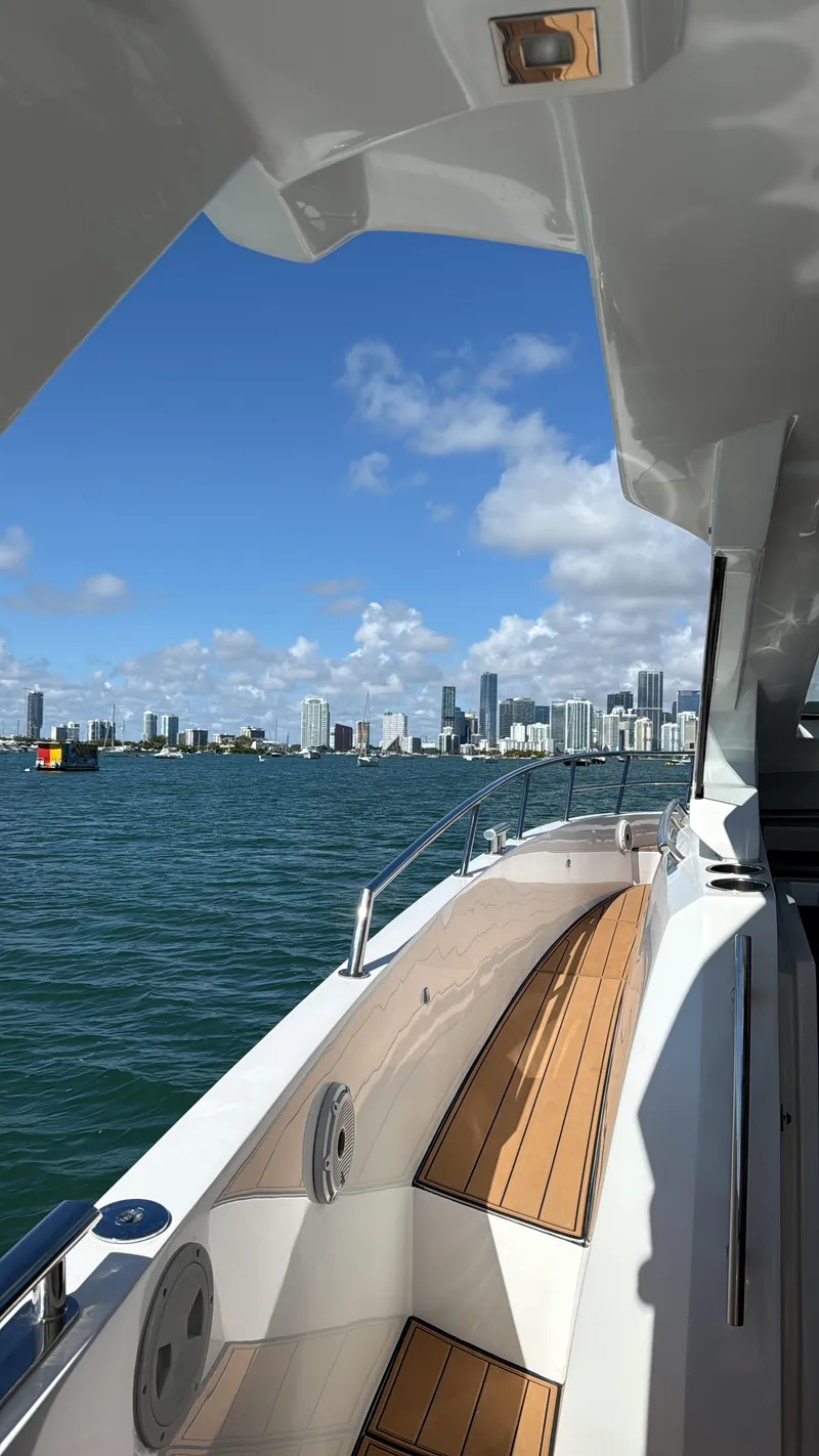 Slide: The Image of 2019 Azimut 40 Verve yacht cruising near a city skyline under a clear blue sky. - 27