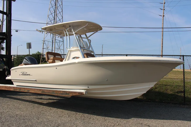 Slide: The Image of 2025 Pioneer 222 Islander boat on trailer, beige color, parked outdoors. - 12